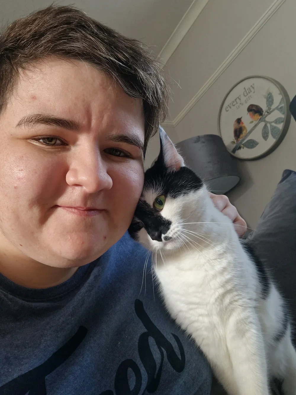 Alex Foley rests her head against a black-and-white cat who is nuzzling her cheek.
